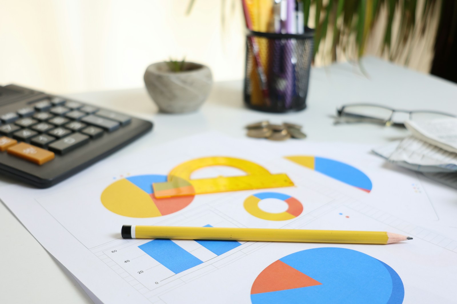 Desk with a calculator, financial charts, and printed reports